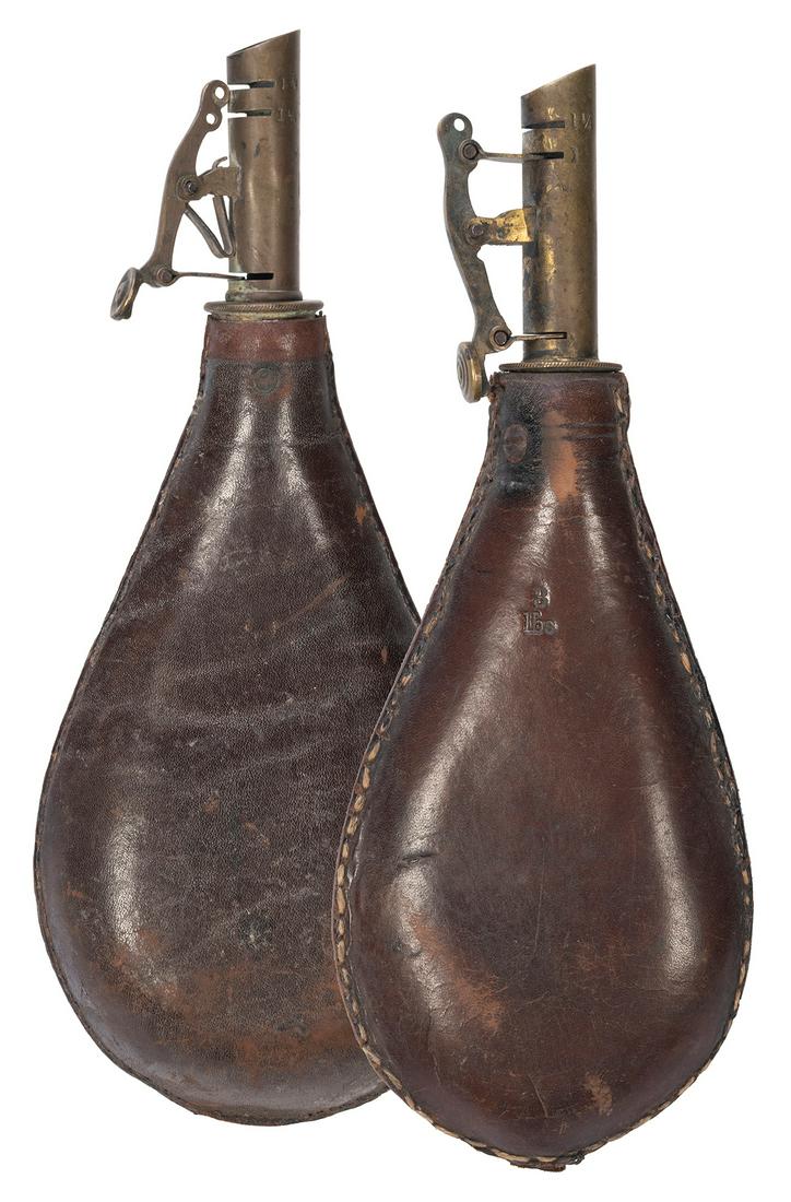 Pair of A.M. Flask & Cap Co. Leather Gunpowder Flasks.: Pair of A.M. Flask & Cap Co. Leather Gunpowder Flasks. Including: A.M. Flask & Cap Co. leather gunpowder bag. Circa 19th century. “6 lbs.” stamped on bag. Length 9 ½”. – A