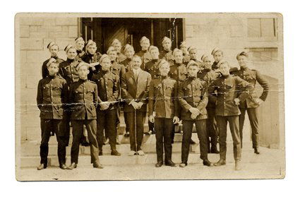 Real-photo postcard-sized image of Dai Vernon in m: Vernon, Dai. Cadet Dai Vernon. Real-photo postcard-sized image of Dai Vernon in military dress, amongst a group of similarly-attired young men. Likely taken during his years at the Royal Military Coll