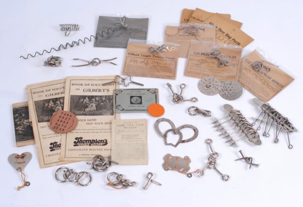 Collection of Mysto/AC Gilbert Co. Metal Puzzles: [Puzzles] Accumulation of Mysto Co. metal and wire puzzles. Including horseshoe, heart, Gilbert Twin Rings, Heathen Ring Puzzles, Nail Puzzle, Mysto Crosses, Wishbone Puzzles, books of solutions, and 