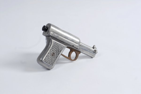 Silk Gun magic trick, ca. 1940.: Silk Gun. Clearwater Kansas, Chambers Manufacturing, ca. 1940. Mechanical cast aluminum faux-pistol automatically vanishes a handkerchief draped over its barrel when the trigger is pulled. Light wear.