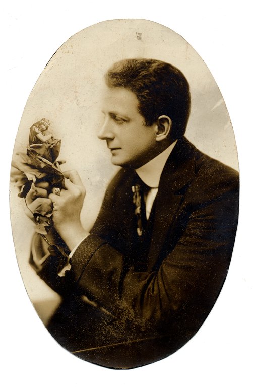 Studio portrait of The Great Leon. ca. 1918: Leon, Leon. Studio portrait of The Great Leon. N.p., n.d. (ca. 1918). Sepia-toned ¾ length image of Leon producing his wife (in miniature) from a flower held in his hands. Neatly trimmed to an oval s