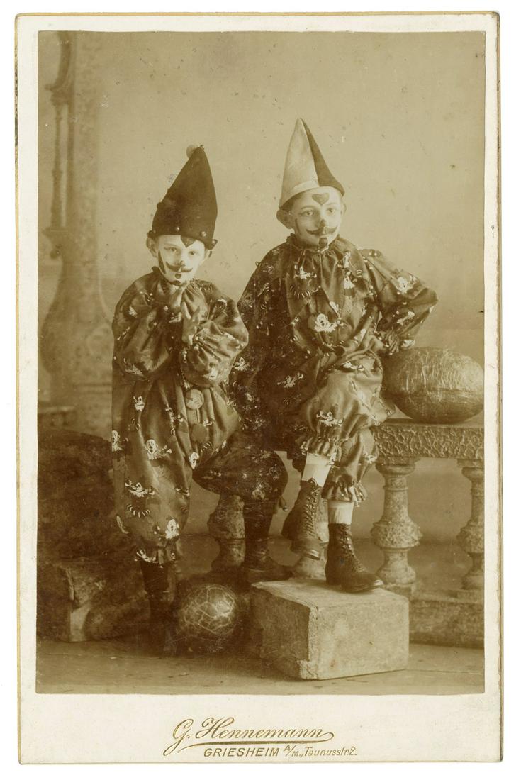 Portrait of two Children Dressed as Clowns. Griesheim:: Portrait of two Children Dressed as Clowns. Griesheim: G. Hennemann, ca. 1880. Full-length photograph of two young boys in elaborate clown costumes and hats with equally elaborate face paint. Gilt sta