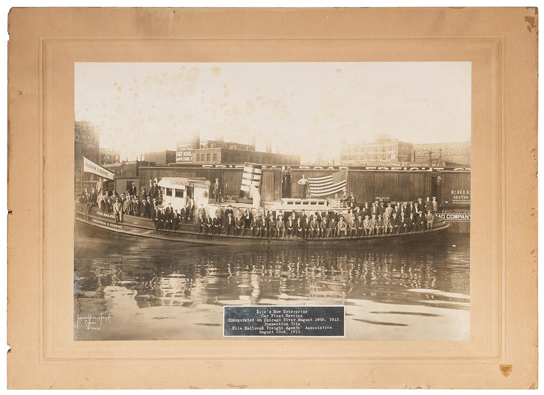 [CHICAGO]. KAUFMANN, WEIMER & FABRY CO., photographers.: [CHICAGO]. KAUFMANN, WEIMER & FABRY CO., photographers. Erie’s New Enterprise Car Float Service Inaugurated on Chicago River August 18th, 1913. Gelatin silver print on original studio mount with