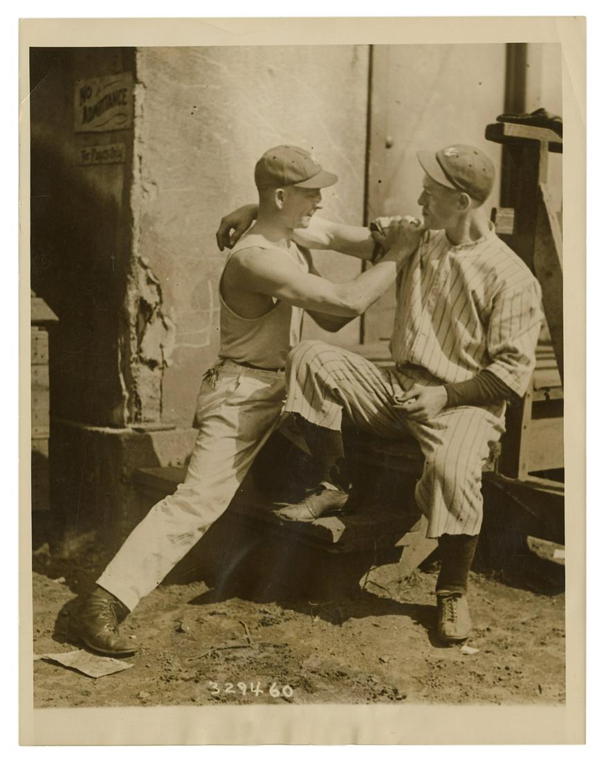 [BASEBALL]. Photograph of “Bullet” Joe: [BASEBALL]. Photograph of “Bullet” Joe Bush, New York Yankees pitcher. 1924. Original press photo of Bush having his arm massaged by Albert Woods. Mimeographed snipe dated 9-18-24. 8 ½