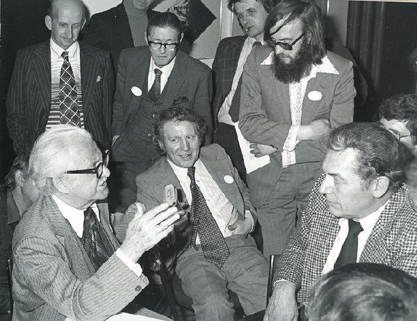 Two photographs of Dai Vernon and Fred Kaps: Vernon, Dai. Two photographs of Dai Vernon and Fred Kaps. Sutton, Bennett and Eagen, ca. 1977. Likely taken at the Ramsay Reunion convention, Vernon holds court for a small crowd of magicians, among t