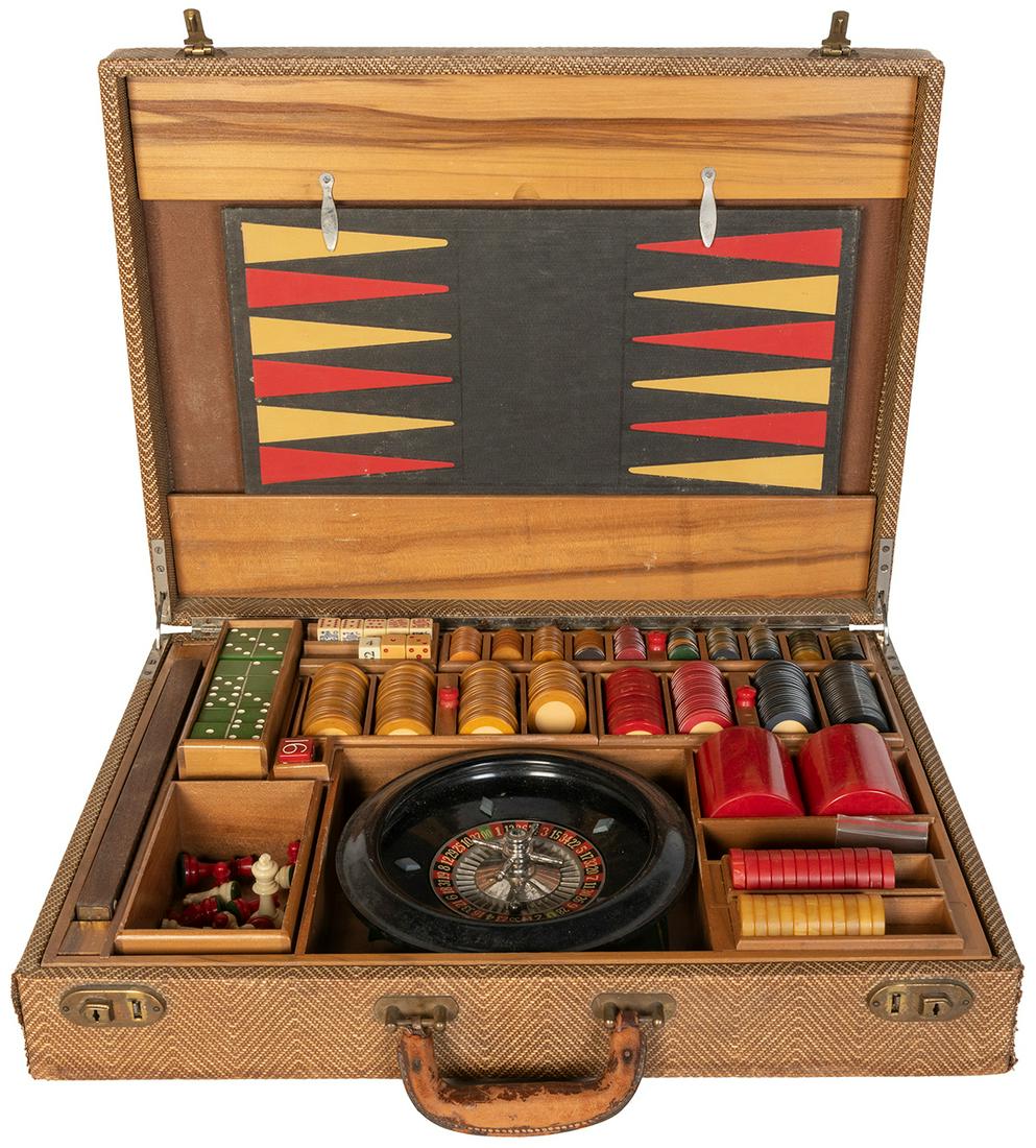 A Mid-Century Bakelite Multi-Game Gaming Set.: A Mid-Century Bakelite Multi-Game Gaming Set. Suitcase-design multi-game set includes a roulette wheel and felt layout (with printed instructions sheet from AP Games), backgammon/chess board, and crib