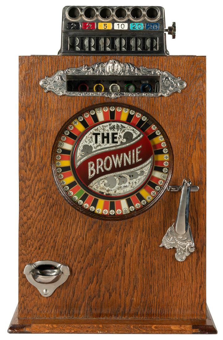 Watling Mfg. Co. Brownie 5 Cent Slot Machine. Chicago:: Watling Mfg. Co. Brownie 5 Cent Slot Machine. Chicago: ca. 1925. Six way head, colored wheel, reverse glass front. Original mechanism. 27 x 11 x 16”. Pay out with each turn. Keys included. Third