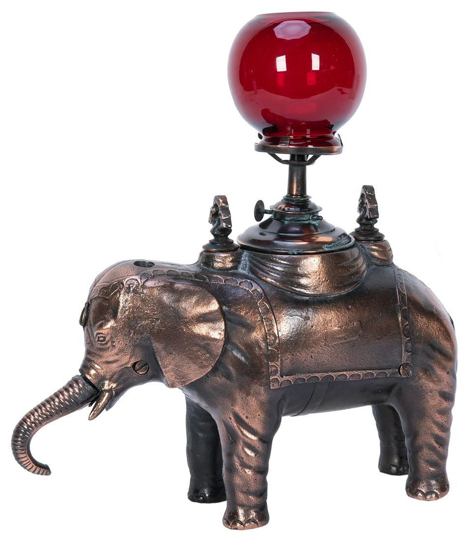 [TOBACCIANA]. Elephant Cigar Cutter. Cast iron elephant: [TOBACCIANA]. Elephant Cigar Cutter. Cast iron elephant with copper wash; lighter and ruby globe. Height, 11 ¾”. Working.