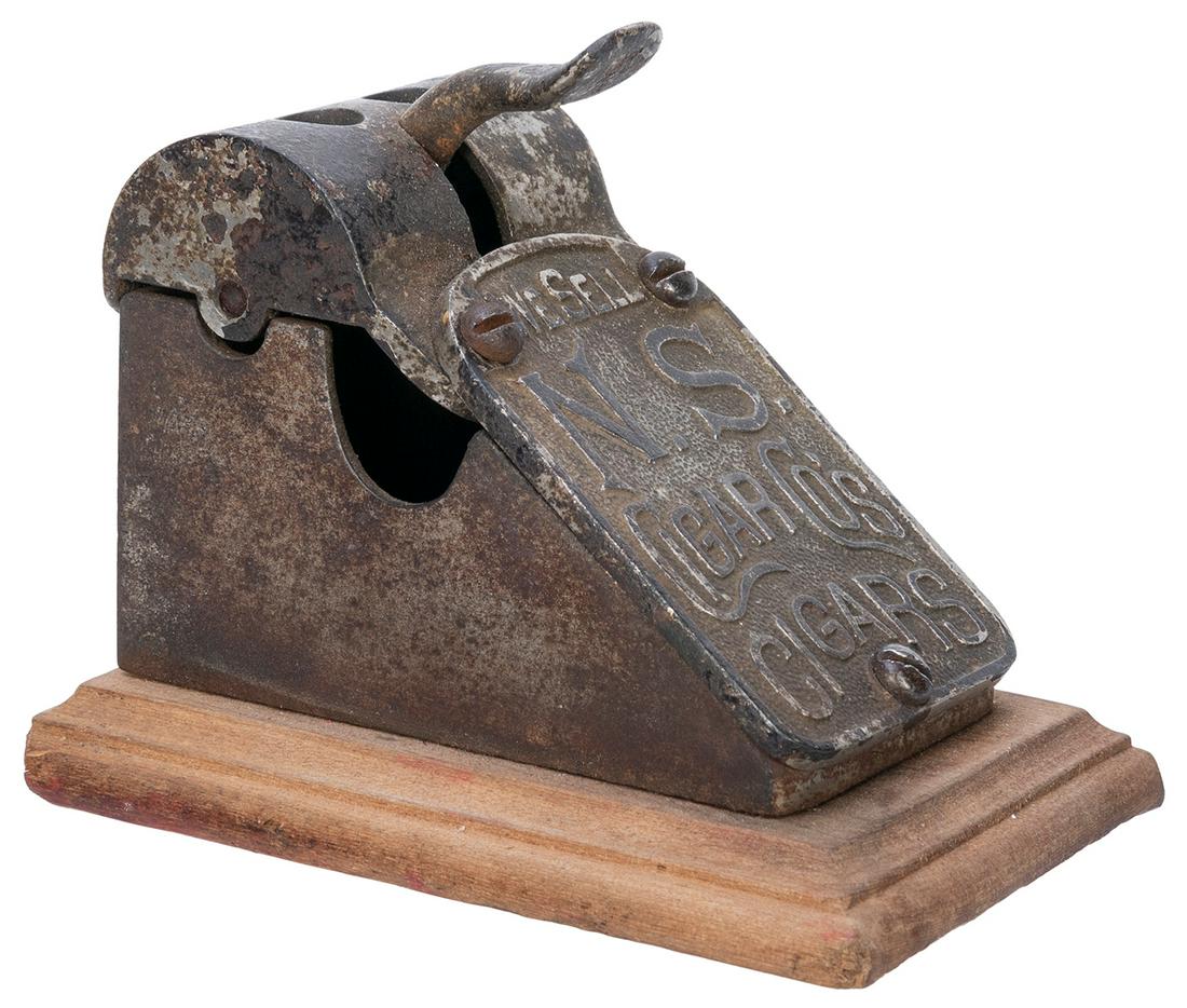 [TOBACCIANA]. N & S Cigar Co. Cigar Cutter. Circa: [TOBACCIANA]. N & S Cigar Co. Cigar Cutter. Circa 1890s. Cigar cutter with two different size holes and mounted on wooden base. Length, 4 ½”.