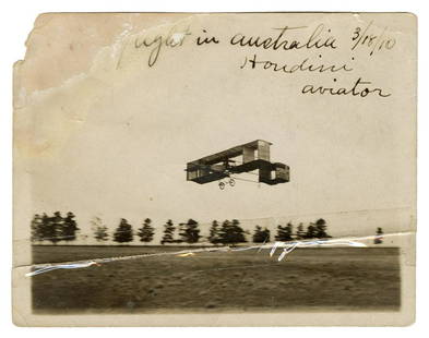 HOUDINI, Harry (Ehrich Weisz). Signed Photograph of Houdini...: HOUDINI, Harry (Ehrich Weisz). Signed Photograph of Houdini’s First Flight in Australia. Dated in Houdini’s hand on March 18, 1910, the image shows Houdini aloft in his Voisin biplane at