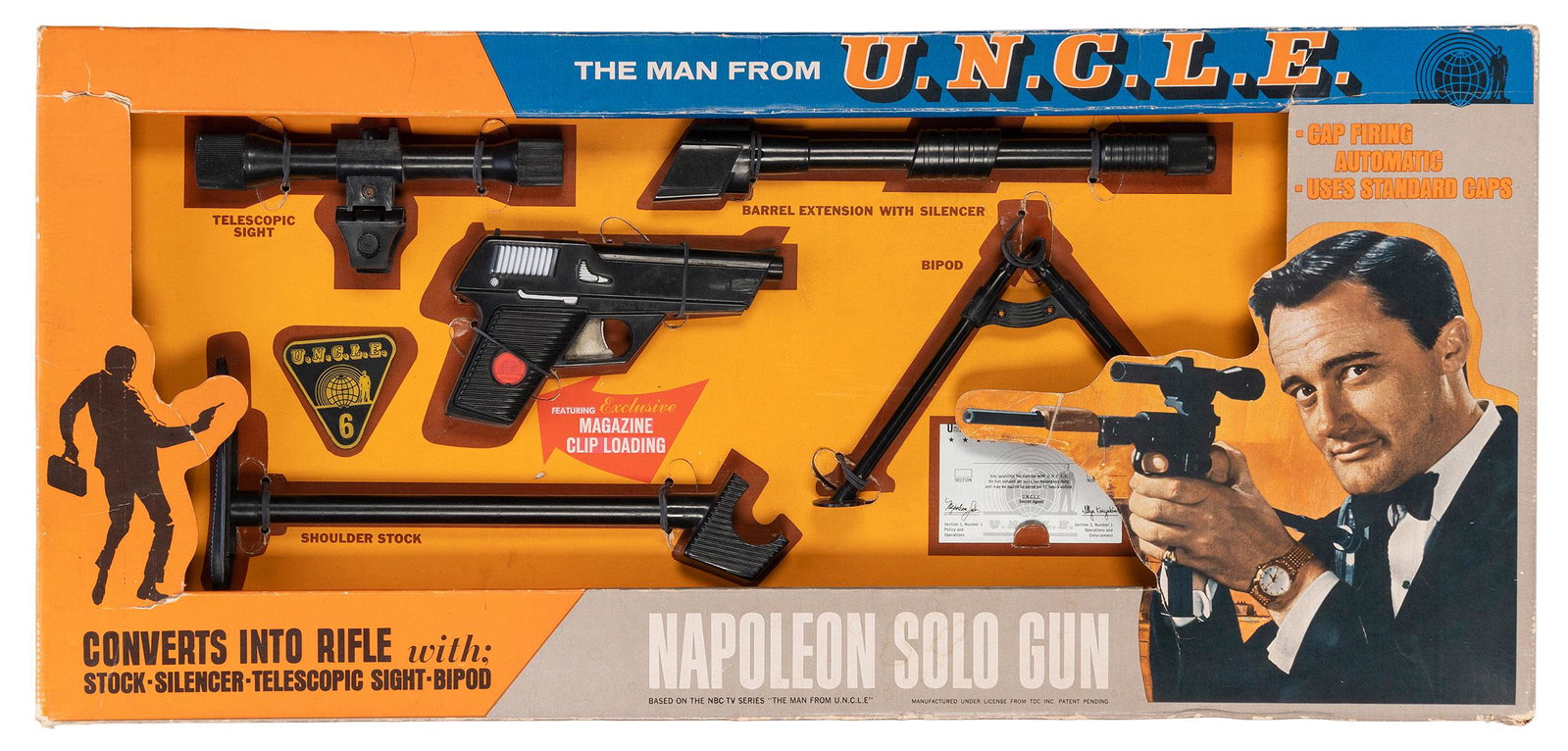 The Man from U.N.C.L.E. Napoleon Solo Gun. Ideal Toy Corp.,...: The Man from U.N.C.L.E. Napoleon Solo Gun. Ideal Toy Corp., 1965. Original large oblong pictorial cardboard display box holding a pistol which converts into a rifle with “stock, silencer, telesc