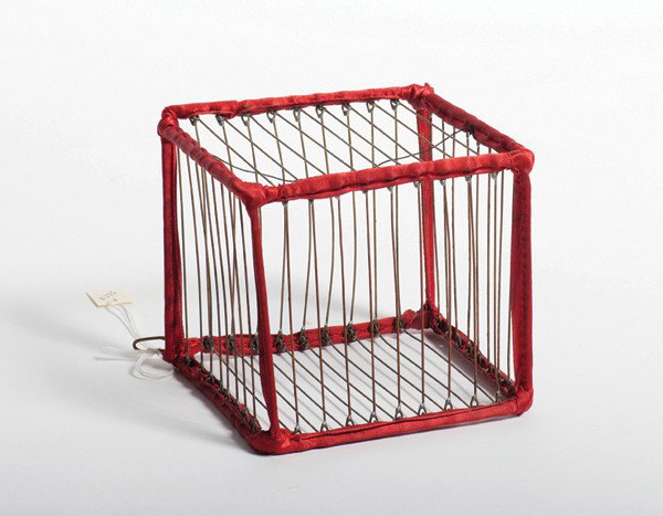 Vanishing Birdcage. Colon Michigan, Abbott's Magic: Vanishing Birdcage. Colon Michigan, Abbott's Magic Novelty Co., ca. 1950. A small brass birdcage bound with red ribbon trim visibly vanishes from the magician's bare hands. 5 ¼ x 4 ¾ x 4 ¾". Good c