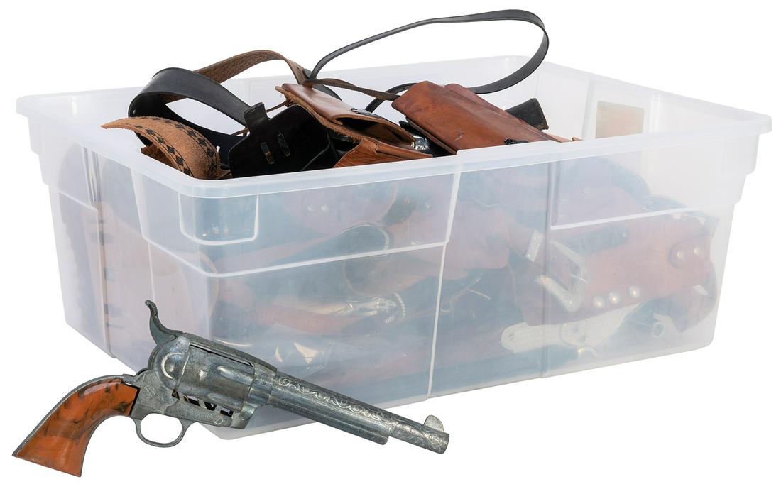 Group of about 20 off-brand plastic or leather holsters, wi...: Group of about 20 off-brand plastic or leather holsters, with 8 off-brand cap guns. [N.p., n.d.]. A large group of assorted plastic or leather holsters (some with belts) and cap guns. Some general wea