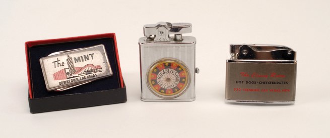 Three miscellaneous Gambling items. Ca. 1940-1960.: Three miscellaneous Gambling items. Ca. 1940-1960. 1 Monte Carlo Roulette Lighter (original box), 1 flat advertising lighter for the “Circus Room” Las Vegas, and 1 money clip & knife from the Mint