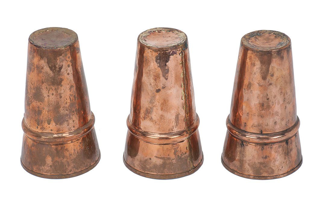 3 Large Copper Cups. Set hand-hammered and formed: Large Copper Cups. Set of three hand-hammered and formed cups used to perform the famous Cups and Balls effect. 6” tall; mouth 3 ½” in diameter. Joints crudely formed. Good.