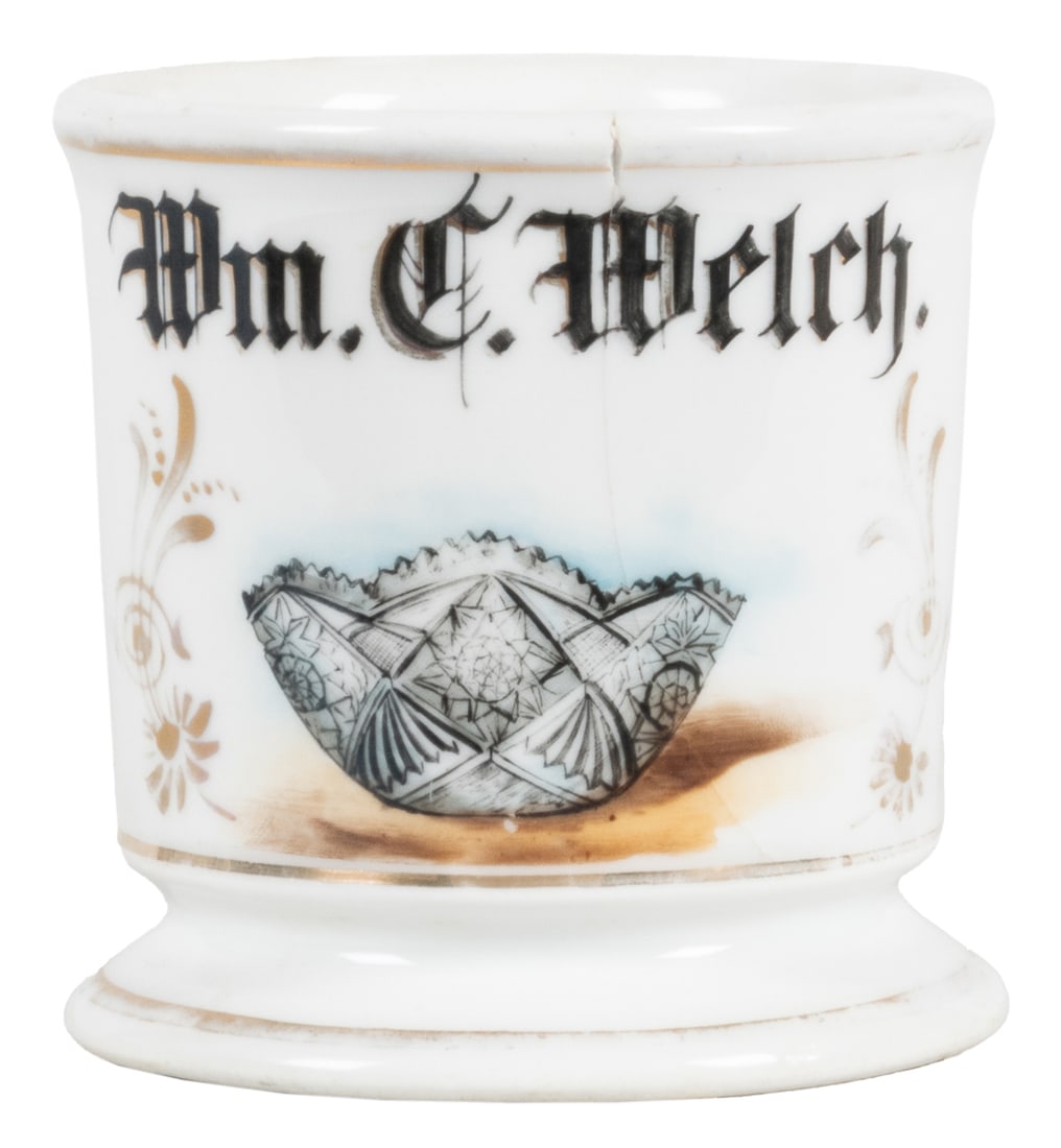 Crystal Bowl Shaving Mug. Black and gilt painted porcelain,...: Crystal Bowl Shaving Mug. Black and gilt painted porcelain, lettered Wm. C. Welch, depicting a decorative crystal bowl. Gilt well rubbed at base and rim. Hairline through image; chip at edge of rim.