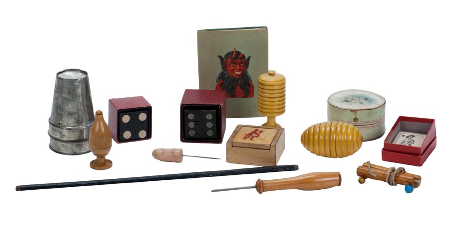 19th c. German Magic Set Components.: [Magic Set] Vintage magic set components. German, ca. 1890. Including wooden egg and millet vases, die through hat (two), Buddha papers, a wand, two tin cups, and various other tricks and puzzles from