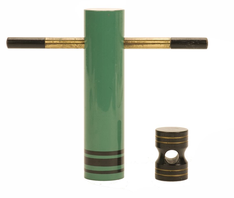 Bomb Atomica. Eddy Taytelbaum: Bomb Atomica. Holland, Eddy Taytelbaum, ca. 1970. A cylindrical wooden block is locked inside a tube with a brass magic wand, then penetrates the wand. Tube stand 5 ¼” high. Wand shows wear. Very g