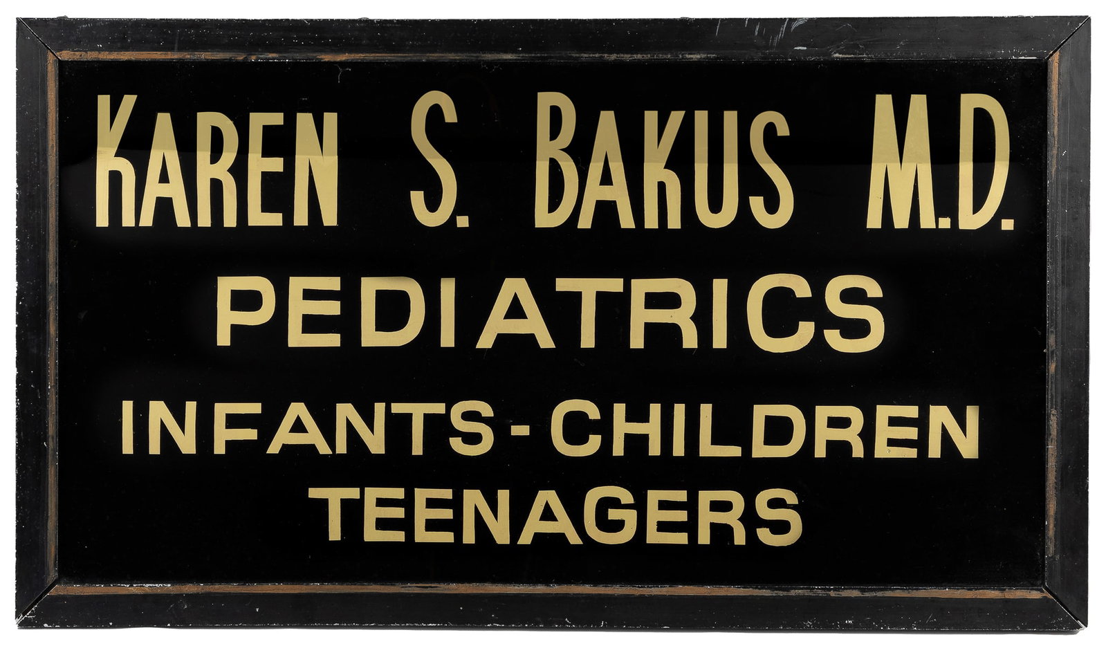 Reverse Glass Pediatrician Sign. Gilt lettering against bla...: Reverse Glass Pediatrician Sign. Gilt lettering against black, in a heavy black metal frame. Advertising Karen S. Bakus MD for care of infants-children and teenagers. 14 ¼ x 25 ¼”. Scr