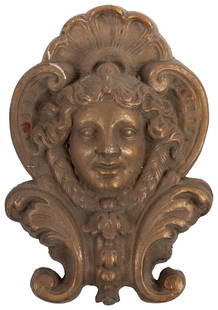 Ornate Gilt Hanging Wall Ornament. Female face relief in ca...: Ornate Gilt Hanging Wall Ornament. Female face relief in cast plaster. Gothic acanthus leaf motifs are incorporated to the bottom margins. 18 x 11”. Chips and surface scratches to finish.
