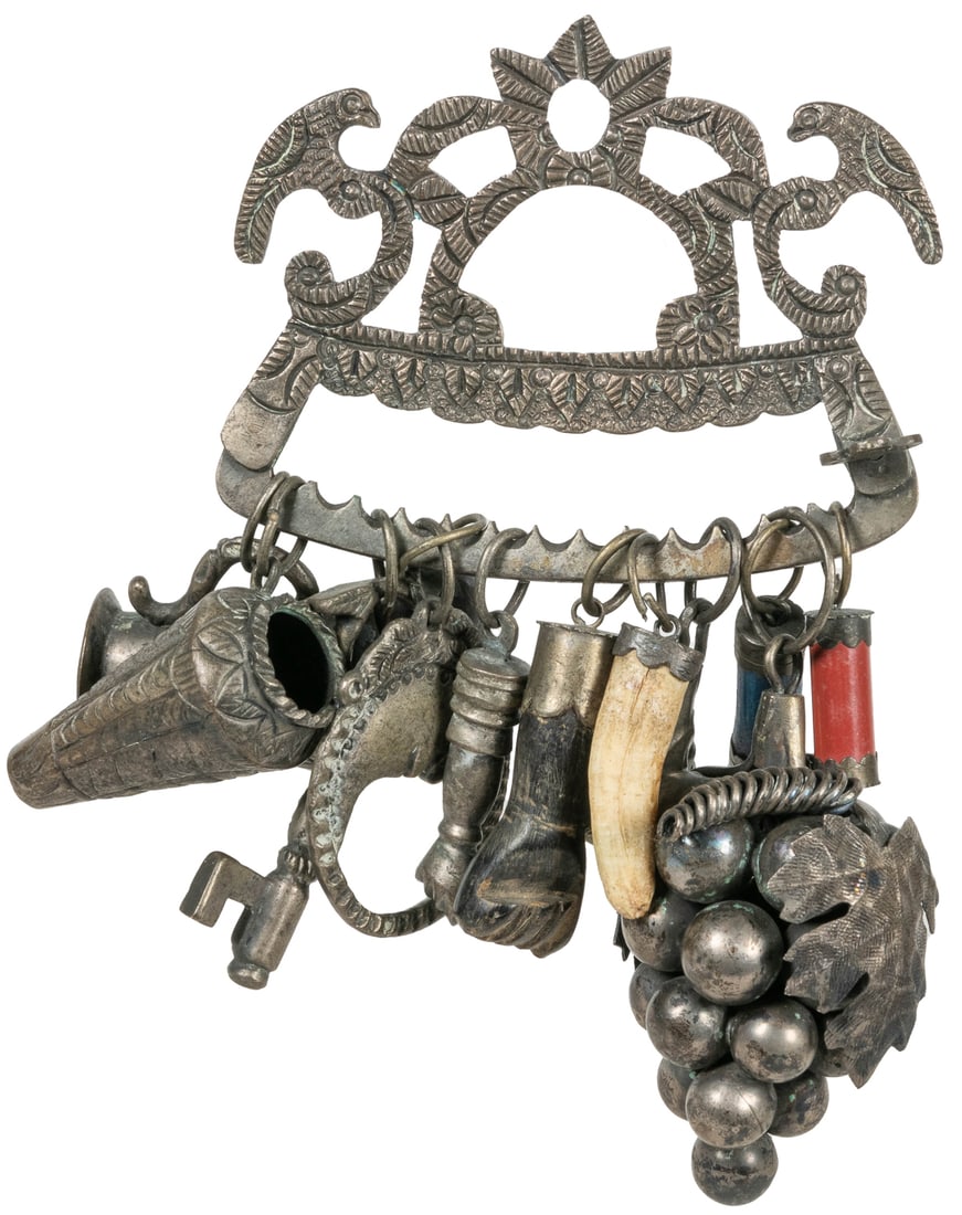 Penca de Balangandan Amulet. Afro-Brazilian, 20th century. ...: Penca de Balangandan Amulet. Afro-Brazilian, 20th century. Collection of 12 charms (metal, bone, carved wood) on cast metal body depicting perched birds 5 ½ x 7 x 1 ½”.