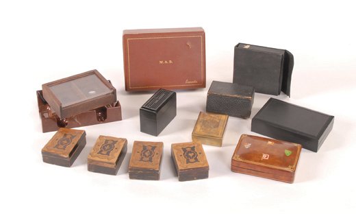 Eleven Playing Card Boxes & Two Canasta Trays. 1900?: Eleven Playing Card Boxes & Two Canasta Trays. Makers unknown, ca. 1900 - ?. Four wooden with inlaid suit symbols on lid, one Italian leather, one brass with the KH engraved on lid, one holds chips an