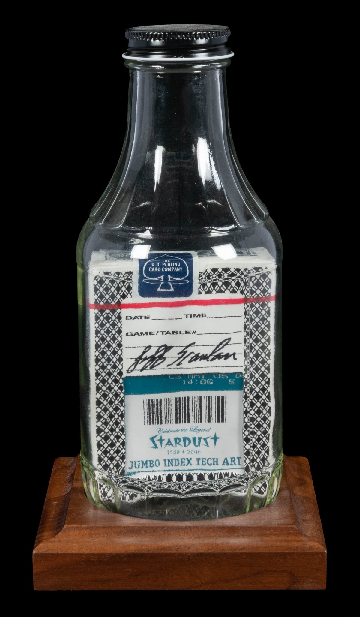 Aristocrat Deck Impossible Bottle. : Aristocrat Deck Impossible Bottle. Arizona: Jeff Scanlan, 2000s. A sealed full box of Aristocrat Playing Cards impossibly placed inside a glass bottle with lid. On a wooden display stand. Height