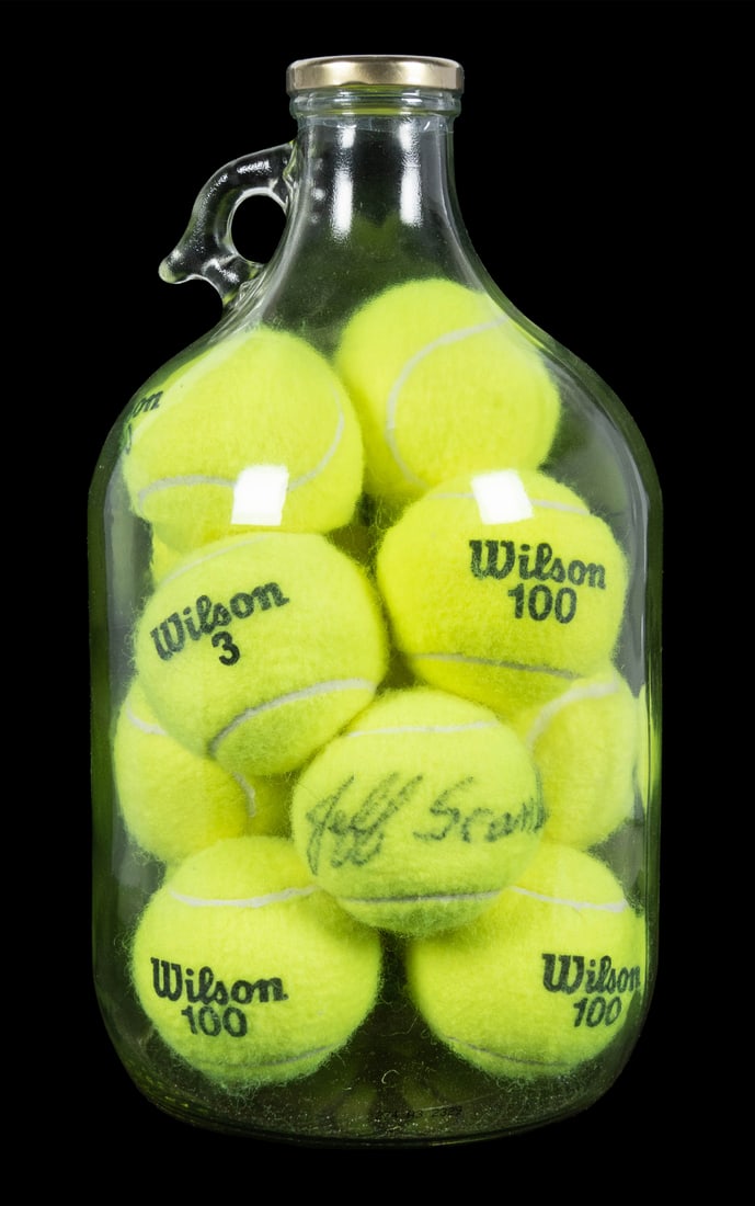 Tennis Ball Impossible Bottle.: Tennis Ball Impossible Bottle. Arizona: Jefxf Scanlan, 2000s. One gallon glass jug filled with Wilson No. 2 tennis balls; each ball was inserted into the bottle without cutting or altering the sphere