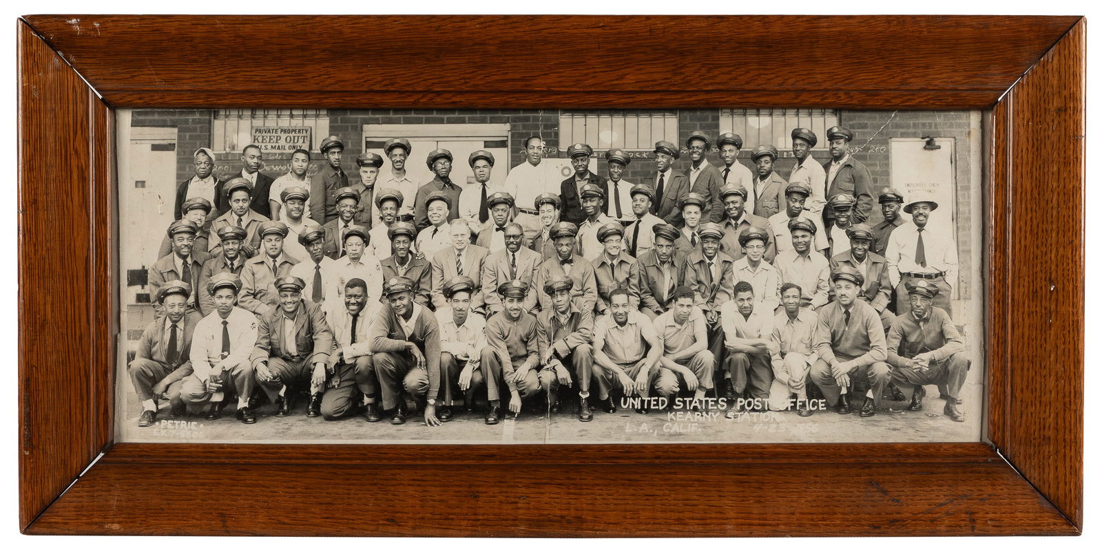 United States Post Office / Kearny Station. Los Angeles, April 23, 1956: [BLACK AMERICANA]. United States Post Office / Kearny Station. Los Angeles, April 23, 1956. Silver gelatin print. Framed group photograph showing Black postal workers of Watts, CA. "Petrie / Ex. 7-560