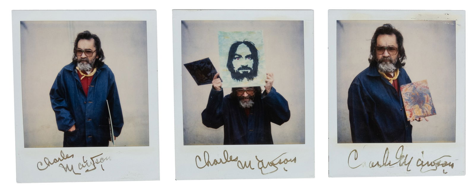 [PRISON ART]. MANSON, Charles (1934-2017). Charles Manson Signed Polaroid Portrait Trio: [PRISON ART]. MANSON, Charles (1934-2017). Charles Manson Signed Polaroid Portrait Trio. Three signed Polaroid photographs featuring Charles Manson posing with three original works. Each 4 1/2 x 3