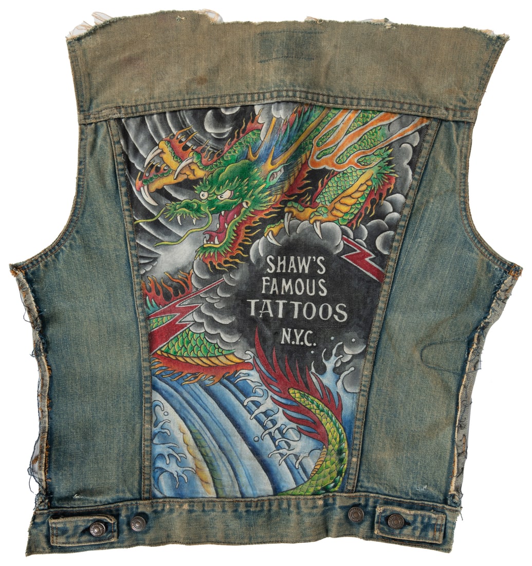 SHAW, Jonathan (1953 - ). "Shaw's Famous Tattoos" Hand-Painted Denim Jacket Panel. New York, ca.: SHAW, Jonathan (1953 - ). "Shaw's Famous Tattoos" Hand-Painted Denim Jacket Panel. New York, ca. 1980s. A Levi's denim jacket (cut-out back only) with a hand-painted design for Shaw's Famous Tattoos,