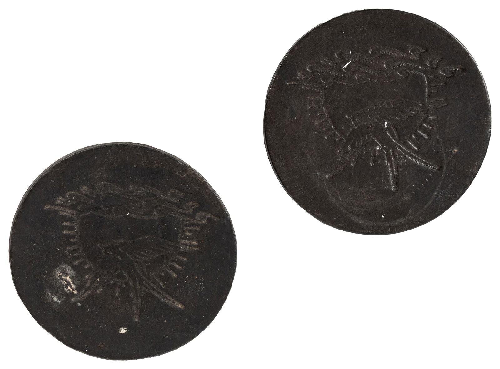 Pirates of the Caribbean Jack Sparrow tattoo leather coasters.: Pirates of the Caribbean Jack Sparrow tattoo leather coasters. Circa 2010s. Two circular leather coasters with the embossed bird tattoo worn by Captain Jack Sparrow in the Pirates of the Caribbean fra