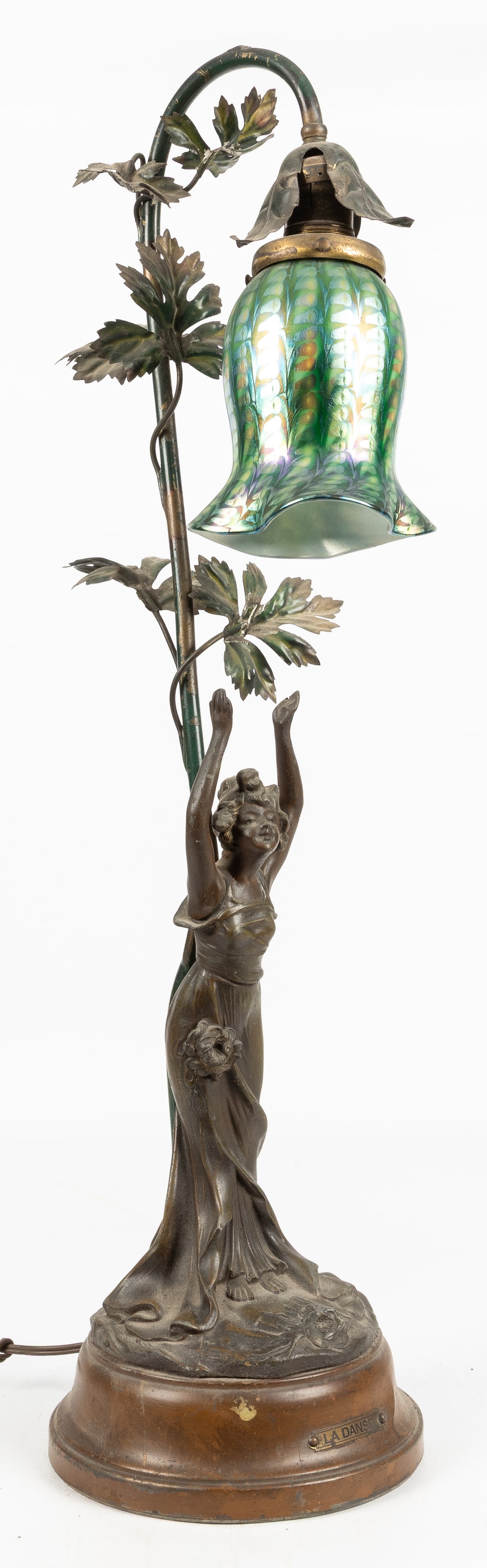 Quezal Art Glass "La Danse" table lamp.: Quezal Art Glass "La Danse" table lamp. Electric desk or table Art Nouveau lamp with figural spelter base bearing "La Danse" title label, with iridescent shade signed by Quezal. 27 x 7 x 7".