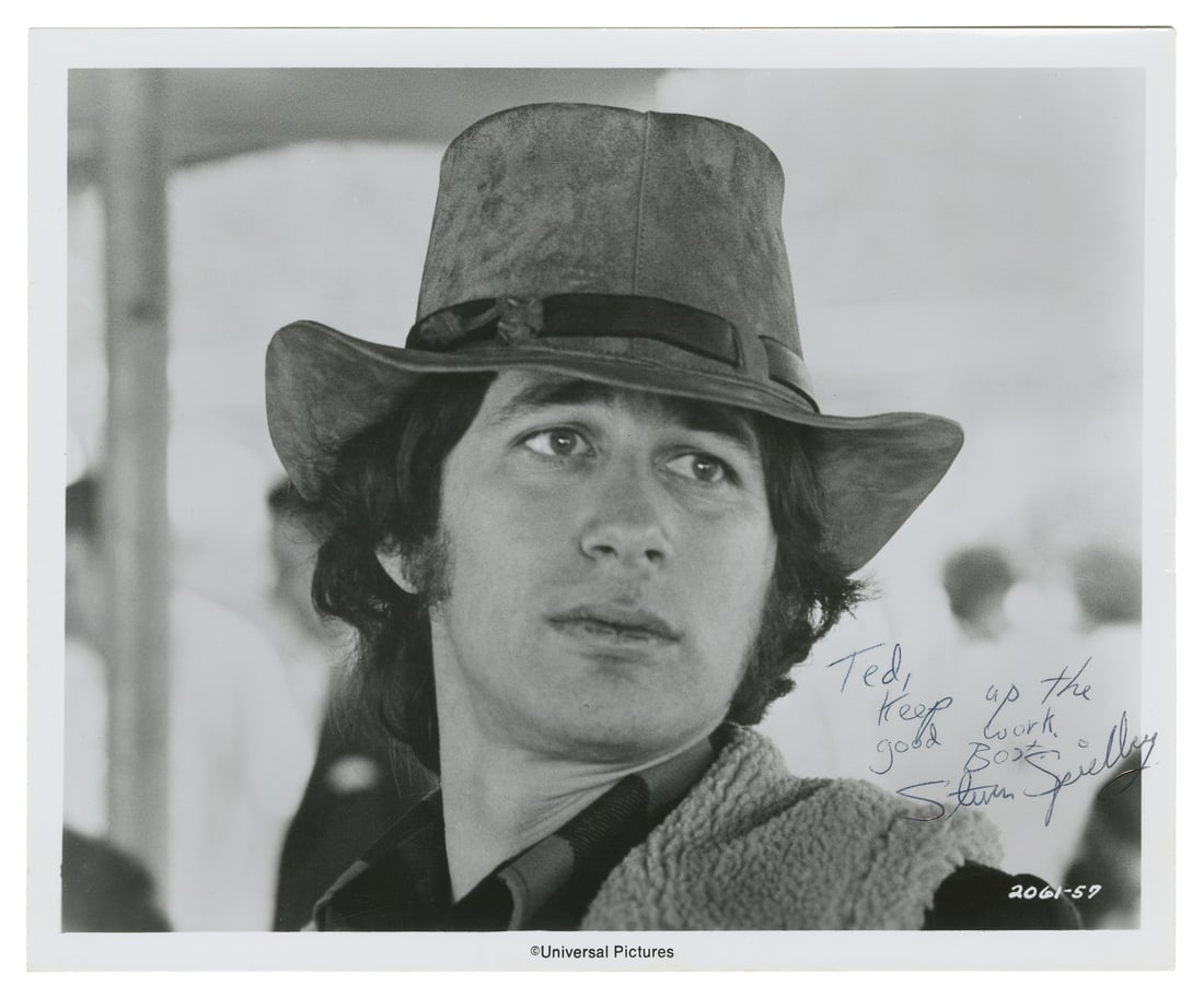 Steven Spielberg signed photograph.: Steven Spielberg signed photograph. 1970s. Glossy publicity photograph of Spielberg as director of The Sugarland Express (1974), inscribed: "To Ted / Keep up the good work. / Best / Steven