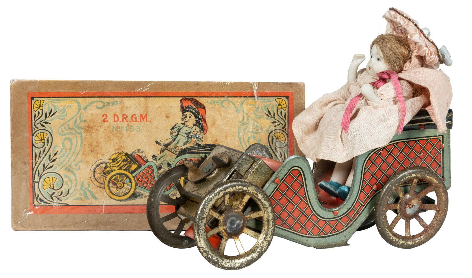 German tin car toy with doll and box.: German tin car toy with doll and box. Circa late 19th / early 20th century. Tin wind-up car with red checkered sides, and chalkware and fabric doll passenger. Includes original box printed "D.R.G.M.