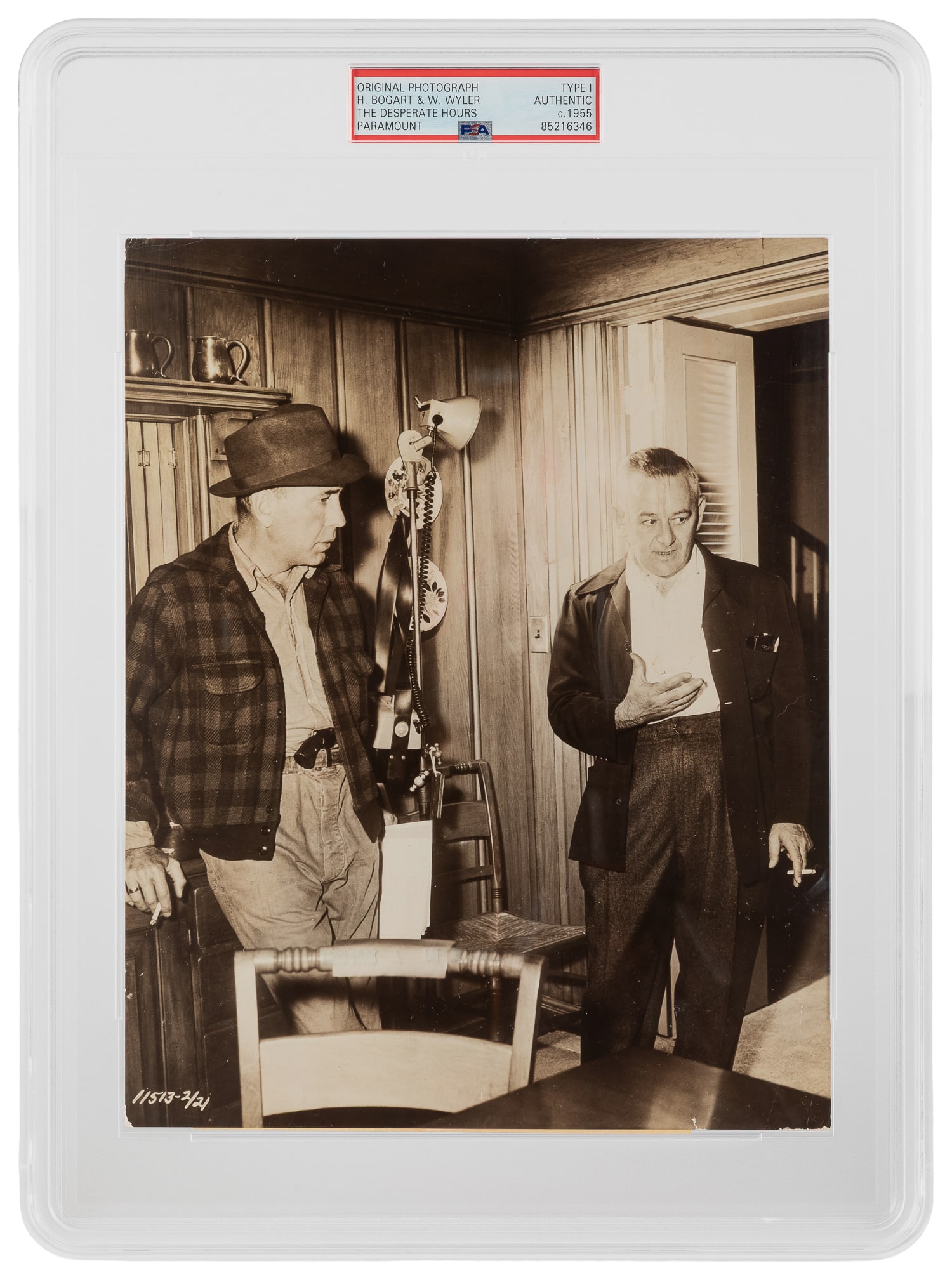 Humphrey Bogart and William Wyler "Desperate Hours" Promotional Photograph (PSA Type I). Paramount,: Humphrey Bogart and William Wyler "Desperate Hours" Promotional Photograph (PSA Type I). Paramount, ca. 1955. Photograph of Bogart and Desperate Hours director William Wyler. Studio snipe affixed on v