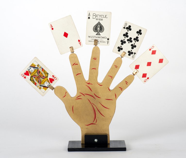 Hand of the Caliph. Abbott's Magic Co., ca. 1965: Hand of the Caliph. Colon Michigan, Abbott's Magic Co., ca. 1965. Five selected cards appear at the tips of the fingers of a wooden cut-out hand. 10 ½" tall. Good.