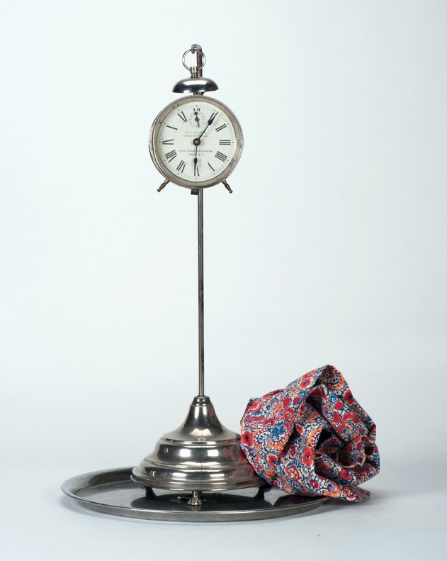 Vanishing Alarm Clock. Sherms, ca. 1940: Vanishing Alarm Clock. Bridgeport Connecticut, Sherms, ca. 1940. An alarm clock covered with a handkerchief and hanging on a nickel-plated stand vanishes at the moment the cloth is removed from the st