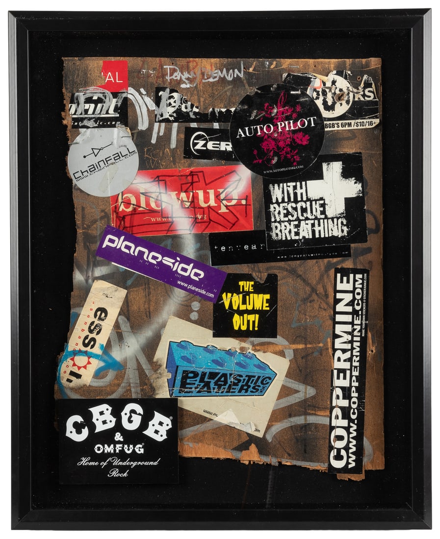 [CBGB & OMFUG CLUB]. Wall Piece from Interior of CBGB, Framed in Shadowbox. [Circa 1973-2000s].: [CBGB & OMFUG CLUB]. Wall Piece from Interior of CBGB, Framed in Shadowbox. [Circa 1973-2000s]. Partially neatly cut wooden wall segment with about 13 stickers or partial stickers, and graffiti, with 