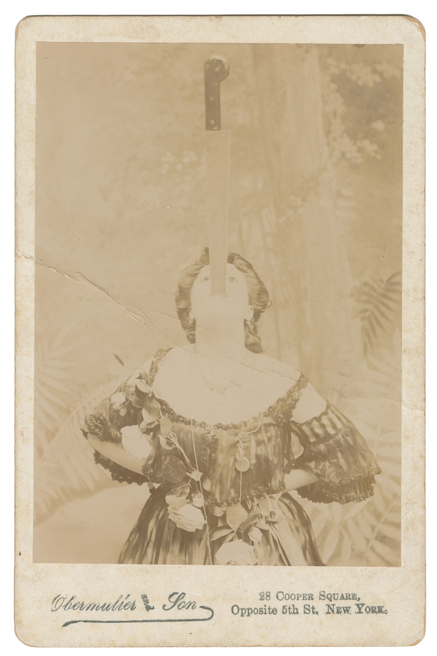 [SWORD SWALLOWER]. Cabinet Photo of a Sword Swallower. Circa 1900.: [SWORD SWALLOWER]. Cabinet Photo of a Sword Swallower. New York: Obermuller & Son, ca. 1900. Sepia-toned image of a female performer shown swallowing a large knife. 6 1/2 x 4 1/4". Likely Melle Cliffo
