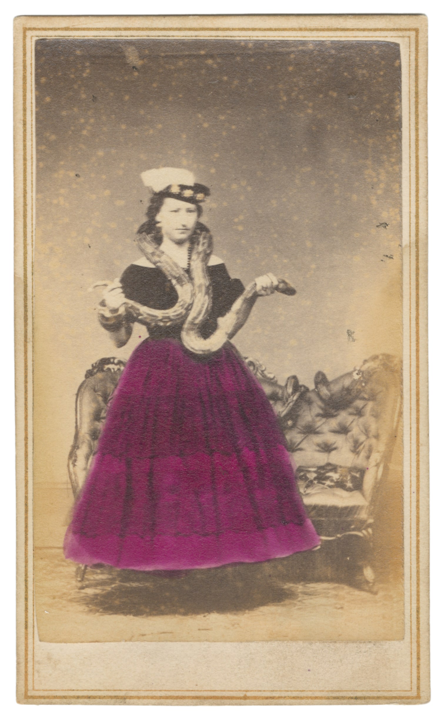 CDV of a snake charmer.: CDV of a snake charmer. Providence, RI: S.B. Brown. Carte de visite with a full length portrait of a woman in hand-colored skirt and fancy hat holding a large snake. 3 7/8 x 2 1/4". Back marked by S.B