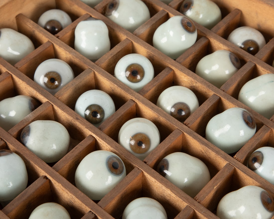 Prosthetic Glass Eye Collection. Group of 171 Brown Glass Eyes in a Wooden Grid Drawer. Early 20th: Prosthetic Glass Eye Collection. Group of 171 Brown Glass Eyes in a Wooden Grid Drawer. German. Early 20th Century. Drawer 13 x 26 ¼”. Eyes approx. 1 1/2 x 1" each. Blown glass, wood case