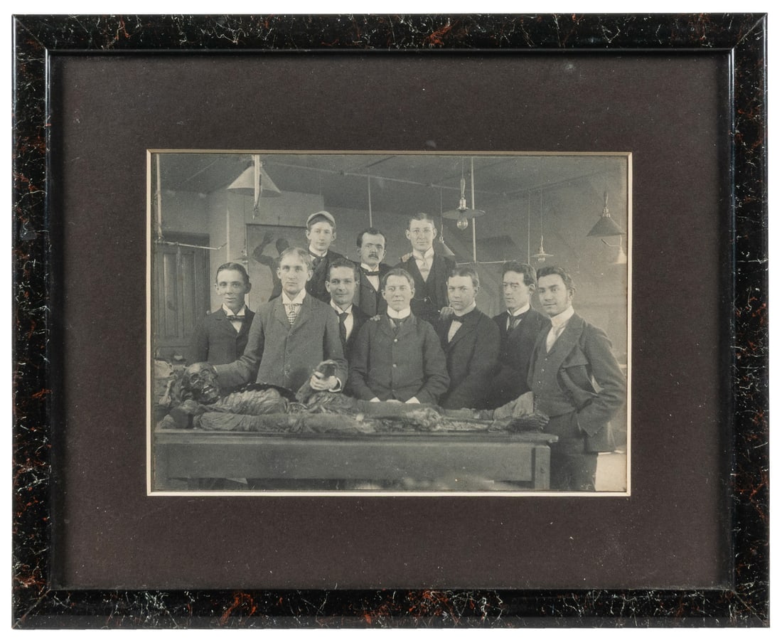 Photograph of a medical college class with cadaver.: Photograph of a medical college class with cadaver. Circa early 20th century. Mounted silver print photograph of a group of young men in a laboratory, posing with a skeleton. Framed. 8 1/2 x 10 1/2"