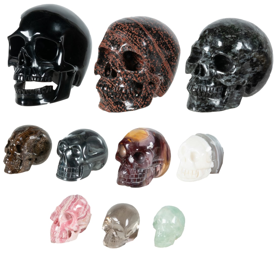 Group of 10 Carved Semiprecious Stone Skulls.: Group of 10 Carved Semiprecious Stone Skulls. Including 3 large (black obsidian, gabbro, and brown snowflake obsidian [China]) and 7 smaller (Mookaite jasper [Australia], hematite, rhodochrosite,