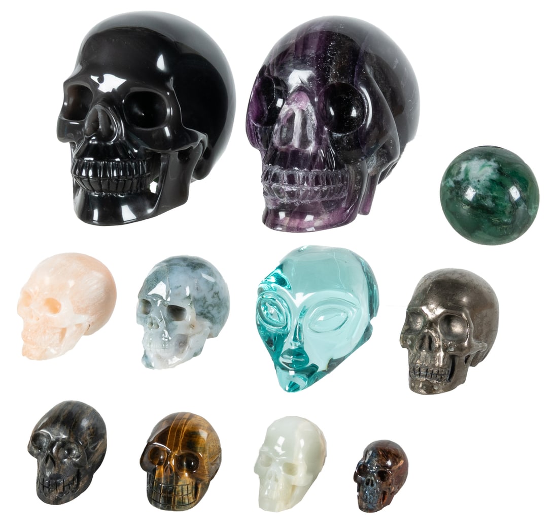 Group 10 Carved Semiprecious Stone Skulls and 1 Sphere.: Group of 10 Carved Semiprecious Stone Skulls and 1 Sphere. Including 2 large skulls (purple fluorite and rainbow obsidian) and 8 smaller (blue-green obsidian, chalcopyrite, selenite, green moss