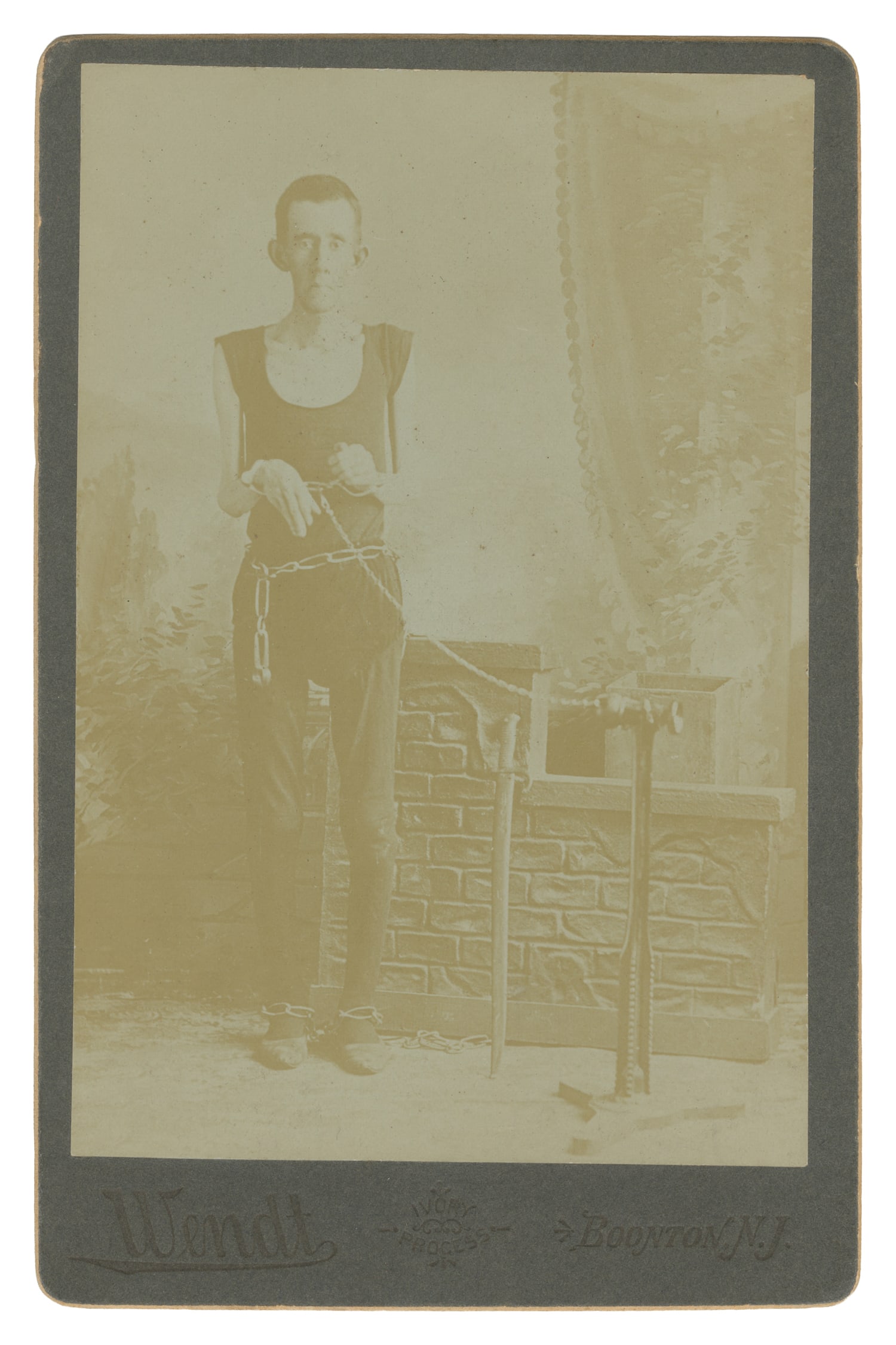 SPRAGUE, Isaac (1841–87). Sideshow Skeleton Man Cabinet Card. Boonton, N.J.: Wendt, ca. 1880s.: SPRAGUE, Isaac (1841–87). Sideshow Skeleton Man Cabinet Card. Boonton, N.J.: Wendt, ca. 1880s. Albumen print on studio mount depicting the performer in chains and handcuffs. 6 1/2 x 4 1/4".