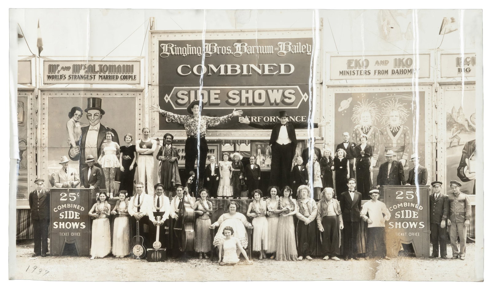 KELTY, Edward J. (1888 - 1967). Ringling Bros. and Barnum & Bailey Combined Side Shows. 1937.: KELTY, Edward J. (1888 - 1967). Ringling Bros. and Barnum & Bailey Combined Side Shows. 1937. New York: Century. Silver print panoramic photograph of the sideshow cast posing in front of hand-painted