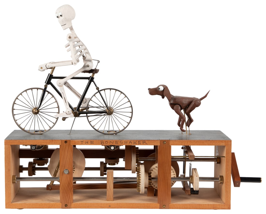 The Boneshaker Automaton.: The Boneshaker Automaton. Cornwall: Fourteen Balls Toy Co., 2011. A skeleton riding a bicycle flees for its life, riding away from the hound that perpetually chases it. As the skeleton pedals, it
