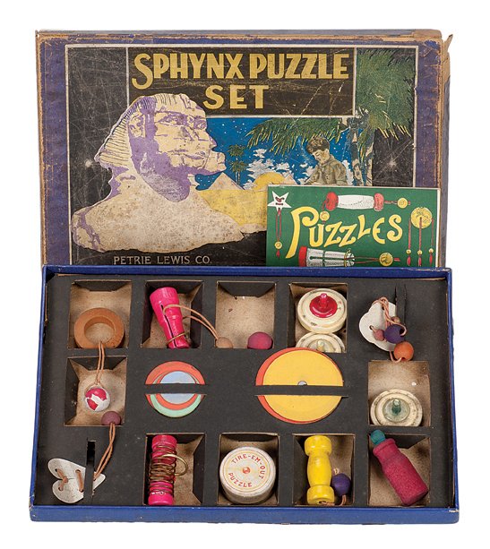 186. Sphynx Puzzle Set. Petrie & Lewis, ca. 1920.: 186. Sphynx Puzzle Set. New Haven Connecticut, Petrie & Lewis, ca. 1920. Lovely American set with lithographed label. Complete, including 13 puzzles and instruction book. Box measures 14 x 9 ¼ x 1”