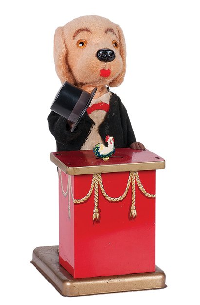 209. Wind-Up "Tricksie" Magician Dog toy. Japan, 1950s.: 209. Wind-Up "Tricksie" Magician Dog toy. Japan, ca. 1950. Tuxedo-clad dog causes an egg to change into a small chicken by raising and lowering a top hat over it. 8 ½" high. Light wear. Good working 